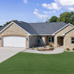 673 Black Earth Exterior. CertainTeed Landmark Driftwood Shingles. De Pere Ledgestone Blend (60% Buff + 40% Blue Vein). Old Carolina Brick Co. Old London #257 Brick. Soldier Course. Rowlocks. Arched Garage Doors. Masonry Archway at Front Entry.