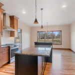 1354 Lucy Ln Kitchen with Granite Countertops, Painted Black Island, Cookbook Display Cabinet, Stained Maple Custom Cabinets, Under-Cabinet Lighting, Tiled Backsplash, Natural Maple Site Finished Hardwood Floors.