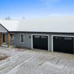 1606 Mapleridge Circle Exterior. Black Windows with White Trim and Gray Siding.