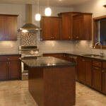 1800 Sonata Kitchen. Custom Stained Maple Flat Panel Cabinets with Granite Countertops, Tiled Backsplash, Under-Cabinet Lighting, and Ceramic Tile Floors.