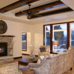 3435 Schubert Living Room. Natural Stone Fireplace Surround. Reclaimed Timber Mantel. Raised Hearth Extension. Tray Ceiling with Hewn Ceiling Beams.