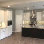 3492 Yorkshire Kitchen. Painted Perimeter Cabinets with Espresso Stained Maple Island. Granite Countertops. Tiled Backsplash. Luxury Vinyl Plank Floors.