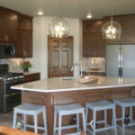 395 Whispering Creek Kitchen. Angled Kitchen Island. Granite Countertops. Tiled Backsplash. Under-Cabinet Lighting. Corner Walk-In Pantry. Upper Cabinets to Ceiling with Glass Doors.