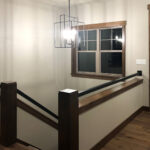6532 Autumn Blaze Trail Foyer. Stairs with Linear Steel Tube and Stained Maple Wall Cap.