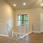 7714 Saint Andrews Foyer + Stairs. Cable Railing with Wood Posts + Rail. Luxury Vinyl Plank Floors. U-Shaped Stairs.