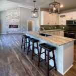 7714 Saint Andrews Kitchen. Peninsula Snack Counter. Floating Shelves. Tiled Backsplash. White painted flat panel custom cabinets. Hutch style upper cabinets.