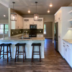 7714 Saint Andrews Kitchen. Peninsula Snack Counter. Floating Shelves. Tiled Backsplash. White painted flat panel custom cabinets. Hutch style upper cabinets.