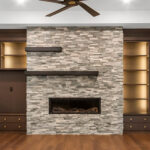 7736 Turnberry Great Room Fireplace + Built-Ins. Modern Linear Stacked Stone Fireplace with Steel Mantels and Flanking Built-Ins.