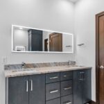 7736 Turnberry Owners Bathroom Vanity. Slab Front Modern Cabinets. Lighted Mirrors. Quartz Countertsops. Ceramic Tile Floors.