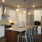 1726 Symphony Heights Kitchen. Painted Perimeter Cabinets with Stained Island. Subway Tile Backsplash. Granite Countertops.