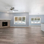 4976 Plum Bottom Rd Living Room. Corner Gas Fireplace with Stacked Stone to Mantel Height. Painted Woodwork. Luxury Vinyl Plank Floors.