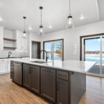 311 S Splake Kitchen. Painted Perimeter Cabinets + Stained Island. Floating Shelves. Tiled Backsplash. Stone Countertops. Chimney Hood over Slide-In Range.