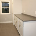 2411 Pristine Laundry. White Painted Base Cabinet & Broom Closet & Laminate Folding Counter.