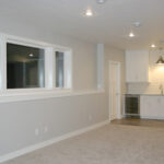 2411 Pristine Rec Area + Wet Bar. Under-Counter Refrigerator. White Subway Tile Backsplash. Pendant Light over Bar Sink. White Painted Flat Panel Cabinets.