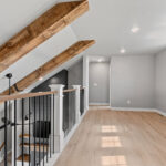 704 Royal St Pats Loft. LJ Smith 4094 Boxed Newel Posts. Plain Square Black Iron Metal Balusters with Concealed Fasteners. Luxury Vinyl Plank Flooring. Hewn Timber Ceiling Beams.