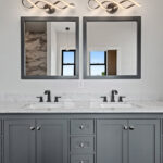 704 Royal St Pats Owners Bathroom Vanity. Painted Gray Vanity with White Stone Countertops. Wood-Framed Mirrors.