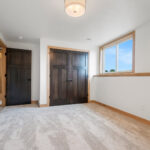 6170 Saint Patrick Basement Bedroom. Half Wall with Maple Wood Cap. Dark Stained Doors with Light Stained Trim.