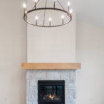 6170 Saint Patrick Fireplace. Stone Fireplace Surround to Mantel Height. Boxed Maple Beam Style 3-Sided Mantel. Luxury Vinyl Plank Flooring.