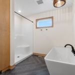 6170 Saint Patrick Owners Bathroom. Tiled Floors with Herringbone Pattern. Free-Standing Tub. Fiberglass Shower Module. Built-In Cabinet Linen.