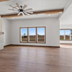 2960 Park Rd Great Room + Fireplace. Brick fireplace surround with reclaimed distressed hewn timber mantel. Luxury vinyl plank floors. Maple ceiling beams.