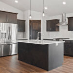 116 Cortland Kitchen. Stained Maple Cabinets. Center Island. Stainless Steel Appliances. Chimney Range Hood. Calacatta Lucia White Quartz Countertops. Luxury Vinyl Plank Floors. Corner Walk-In Pantry.