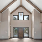2966 Sugar Bush Foyer. Eldorado Cathedral ceiling with window wall and hewn timber ceiling beams. Adura Rigid Plank "Dockside Drift" luxury vinyl plank floors.