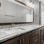 2966 Sugar Bush Full Bathroom. Stained knotty alder cabinets. Fantasy blue leathered granite countertops. Vinyl tile floors.