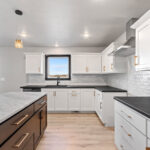 525 E Greenfield Kitchen. White Painted Flat Panel Perimeter Cabinets with Stained Maple Island. Perimeter Laminate Countertops with Granite Island Countertop. White Subway Tile Kitchen Backsplash. Luxury Vinyl Plank Floors. Stainless Chimney Range Hood.