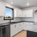 525 E Greenfield Kitchen. White Painted Flat Panel Perimeter Cabinets with Stained Maple Island. Perimeter Laminate Countertops with Granite Island Countertop. White Subway Tile Kitchen Backsplash. Luxury Vinyl Plank Floors. Stainless Chimney Range Hood.