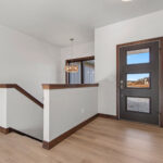 398 Red Tail Foyer & Stairs. Therma-Tru Pulse S2 Entry Door. Half Wall with Maple Cap around Stairwell. Luxury Vinyl Plank Floors.