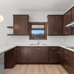398 Red Tail Kitchen. Mid-Century Modern Revival. Flush Slab-Front Stained Maple Cabinets. Floating Shelves. Electric Cooktop. Under-Cabinet Range Hood. Luxury Vinyl Plank Floors.