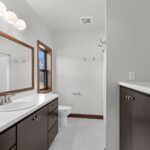 398 Red Tail Owners Bathroom. Mid-Century Modern Revival. Flush Slab-Front Stained Maple Cabinets. Linen with Countertop Above. Wood-Framed Mirror.