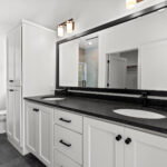 7730 Prestwick Owners Bathroom. Black Granite Countertops. White Painted Woodwork Bathroom Vanity. Black Wood Mirror Frame. Grouted Vinyl Tile Floors.