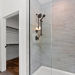 7730 Prestwick Owners Tiled Shower. Tiled Walls with White Fiberglass Shower Base. Heavy Glass Shower Enclosure. Grouted Vinyl Tile Floors. White Painted Woodwork.