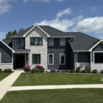 4524 Grande Ridge Exterior. Black Windows with White Trim Boards, White Stone, and Gray LP SmartSide Siding.