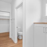 7679 St Andrews Owners Bathroom. Short Cabinetry Linen with Wood Top and Window Above.