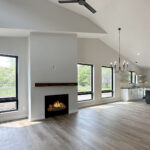 8241 Peil Ln Fireplace + Living Room + Dining Room. Plastered Drywalled Fireplace Surround with Beam Style Mantel. Luxury Vinyl Plank Floors. Black windows with plastered drywalled returns. Active Dormer Cathedral Ceiling.