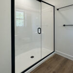8241 Peil Ln Owners Bathroom Shower. Basco Infinity Matte Black Clear Glass Semi-Frameless Shower Door with Fiberglass Shower Module. Luxury Vinyl Plank Floors.