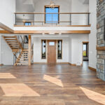 10510 Sugar Creek Foyer + Open Riser Stairs. Maple Glu-Lam, Black Cable Rail, Ceiling Beams.