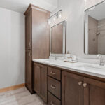 14421 N Paya Lake Rd Basement Bathroom. Stained maple vanity cabinet with Calacatta Coloma granite countertops. Adura Flex "White Cap" vinyl tile.