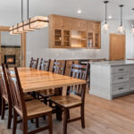 14421 N Paya Lake Rd Kitchen & Dining Area. Horizon Glossy "Mist" tiled backsplash to ceiling. Cortec Pro "Brookfield Maple" vinyl plank floors. Cascade granite and Silestone "Miami Vena" countertops. Corner Walk-In Pantry. Glacier White painted island with stained flat panel maple perimeter cabinets with floating shelves and glass doors. Microwave in corner cabinet. GE black slate appliances. Slide-in gas range. Under-counter beverage refrigerator.