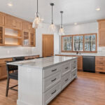 14421 N Paya Lake Rd Kitchen. Horizon Glossy "Mist" tiled backsplash to ceiling. Cortec Pro "Brookfield Maple" vinyl plank floors. Cascade granite counertops. Corner Walk-In Pantry. Glacier White painted island with stained flat panel maple perimeter cabinets with floating shelves and glass doors.
