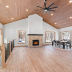 14421 N Paya Lake Rd Three Seasons Room & Fireplace with Stacked Stone Surround to Mantel Height. Tuscany Scabas natural stacked stone panels with Evostone "Dune" hearth tile. Heatilator Pioneer II wood-burning fireplace. Cedar tongue-in-groove T&G ceiling finished with Sherwin-Williams SW3507 "Riverwood" semi-transparent stain. Cortec Pro "Brookfield Maple" vinyl plank floors. Open level railing with black iron balusters.