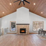14421 N Paya Lake Rd Three Seasons Room & Fireplace with Stacked Stone Surround to Mantel Height. Tuscany Scabas natural stacked stone panels with Evostone "Dune" hearth tile. Heatilator Pioneer II wood-burning fireplace. Cedar tongue-in-groove T&G ceiling finished with Sherwin-Williams SW3507 "Riverwood" semi-transparent stain. Cortec Pro "Brookfield Maple" vinyl plank floors. Open level railing with black iron balusters.