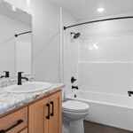 2202 Patty Ln Main Bathroom. Light stained maple vanity cabinet. Formica White Ice Granite 9476-58 countertops.